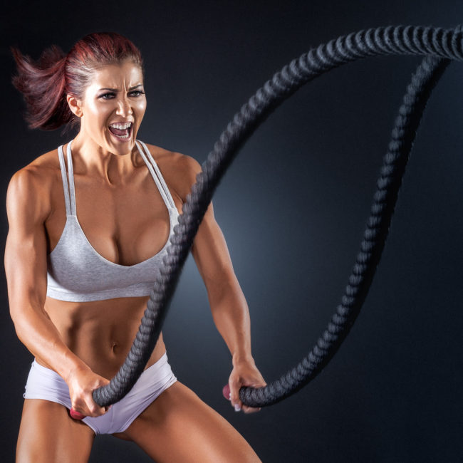 fitness image of woman using battle ropes