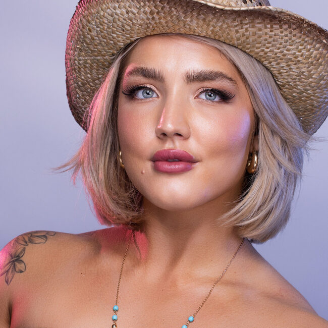 Portrait of woman in the studio in Ventura with magenta light accenting her hair